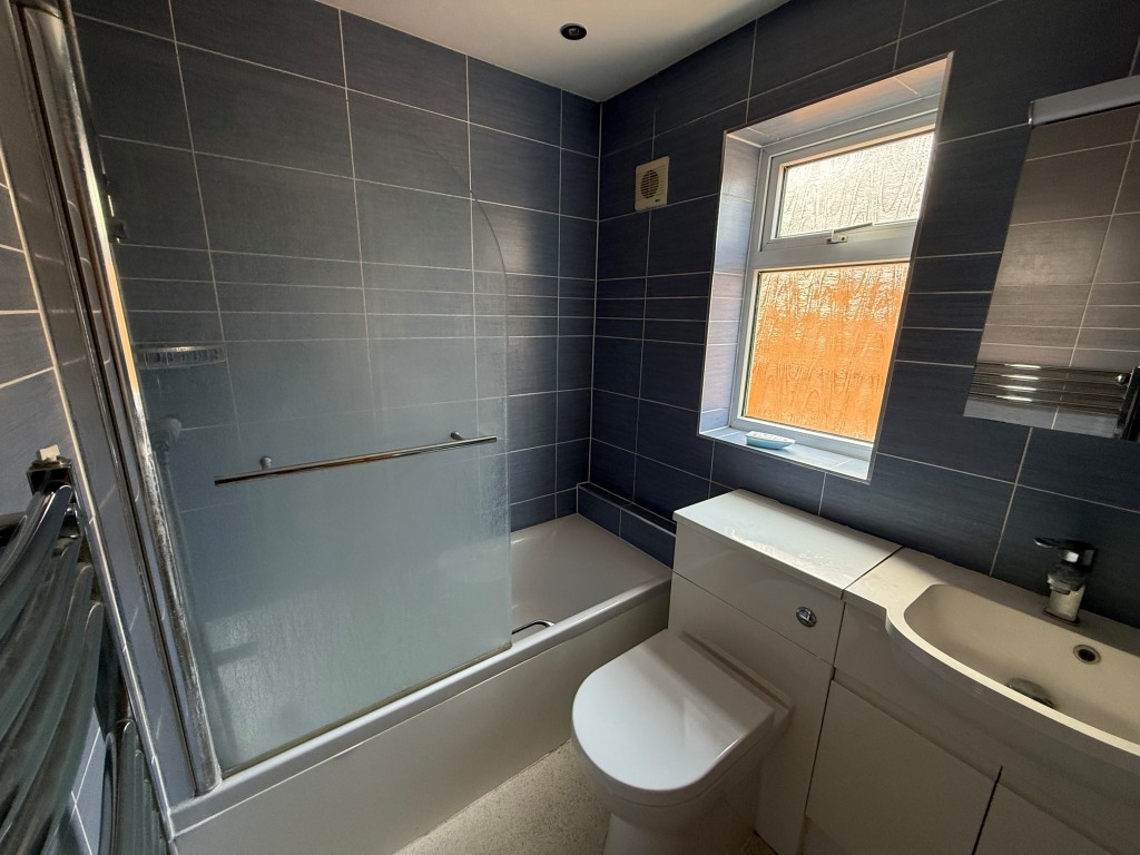 Lot: 163 - THREE-BEDROOM DETACHED HOUSE FOR IMPROVEMENT - Tiled ground floor bathroom with bath, sink and shower